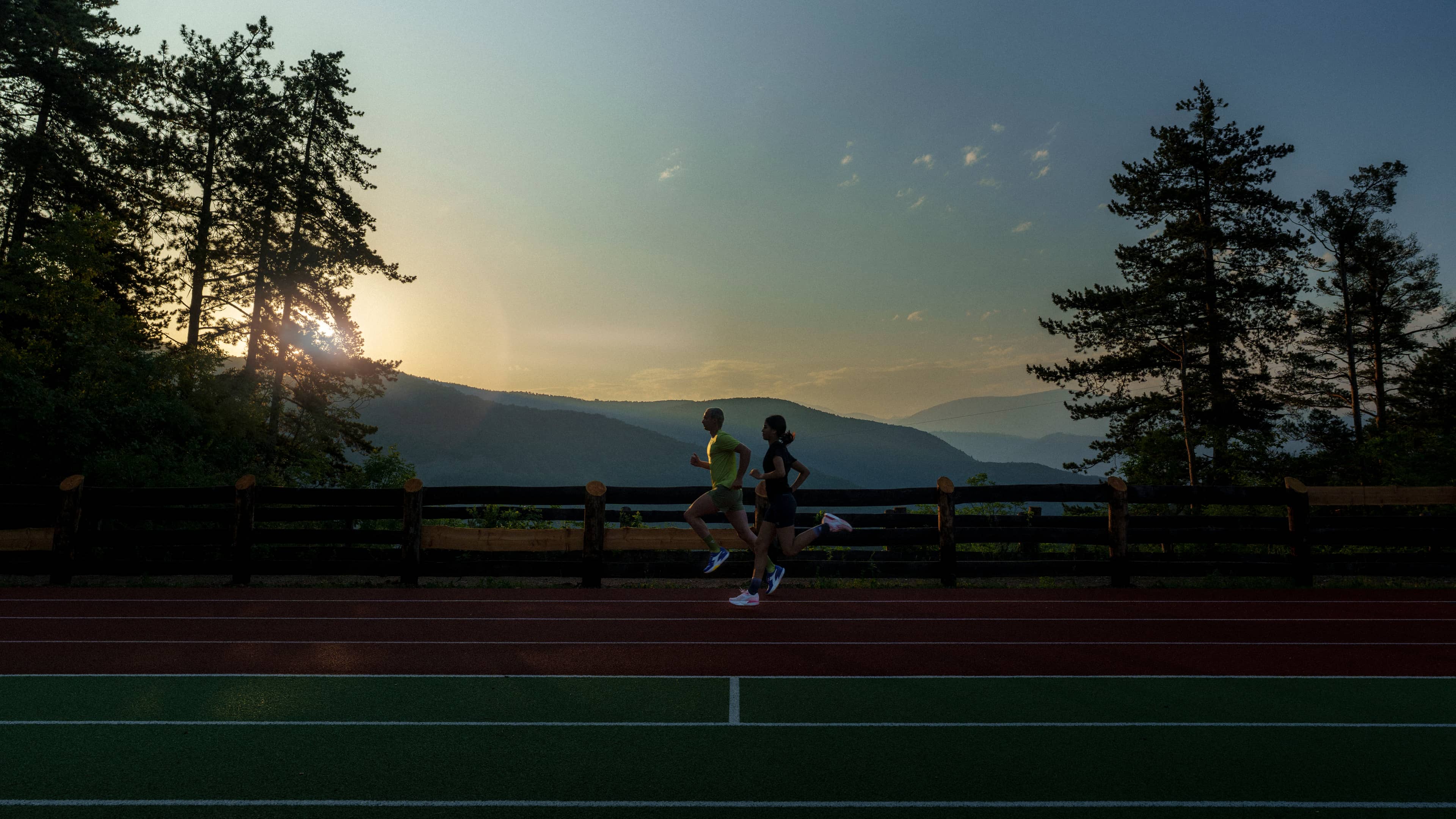 Two runners training on an outdoor track for the Diadora Own the Track challenge