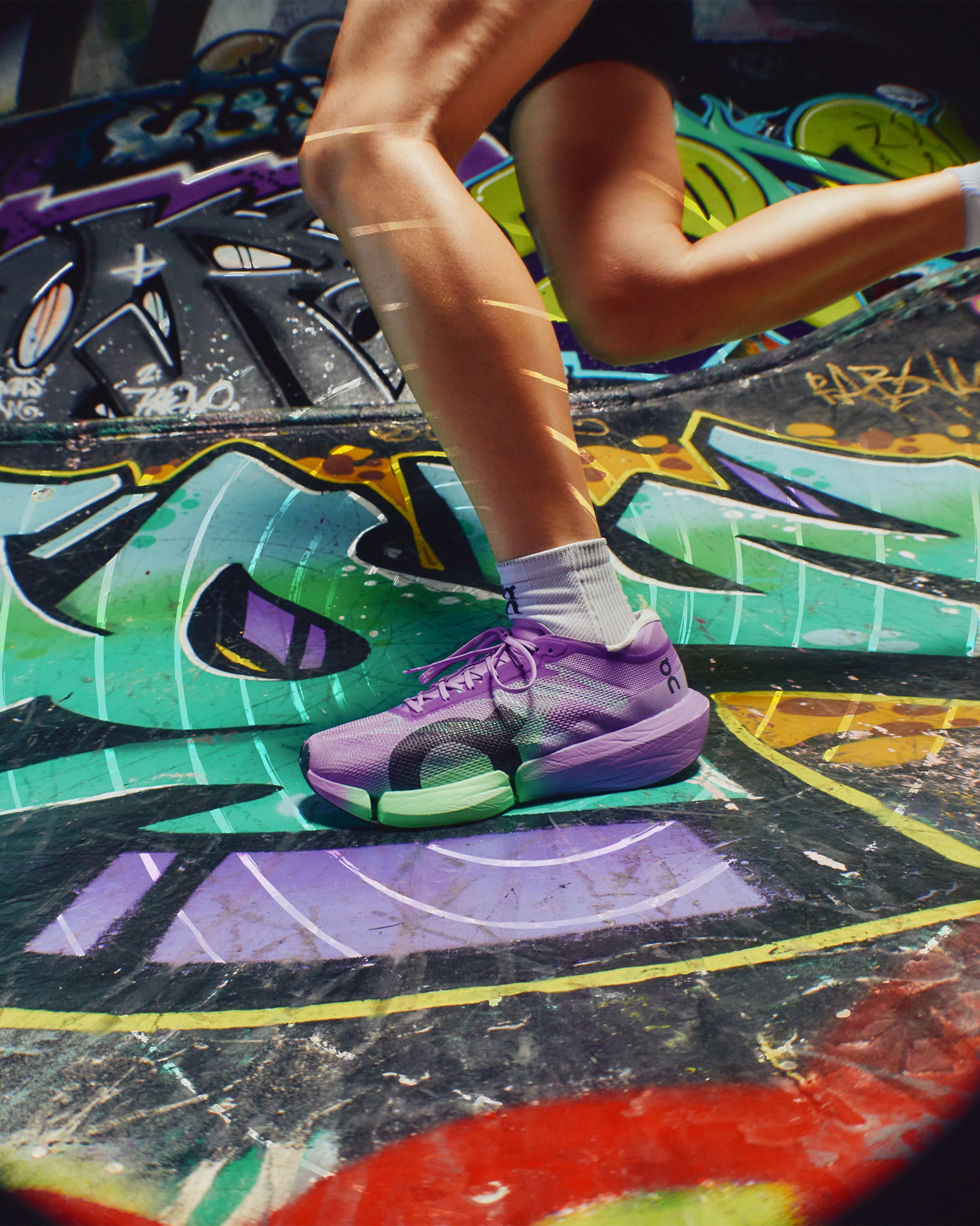 Runner wearing the purple On Cloudboom Strike 2 against a graffiti backdrop